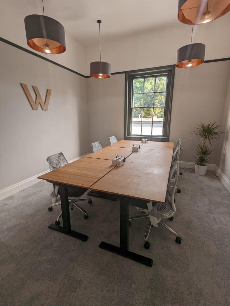 Flexible serviced office in Cheltenham, with a boardroom-style layout of desks and chairs in a spacious Regency room.